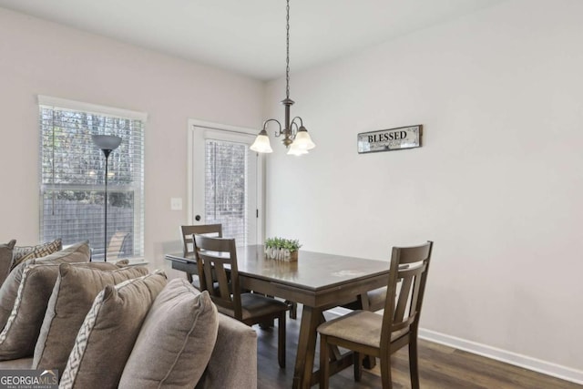 dining space with dark hardwood / wood-style floors and a chandelier