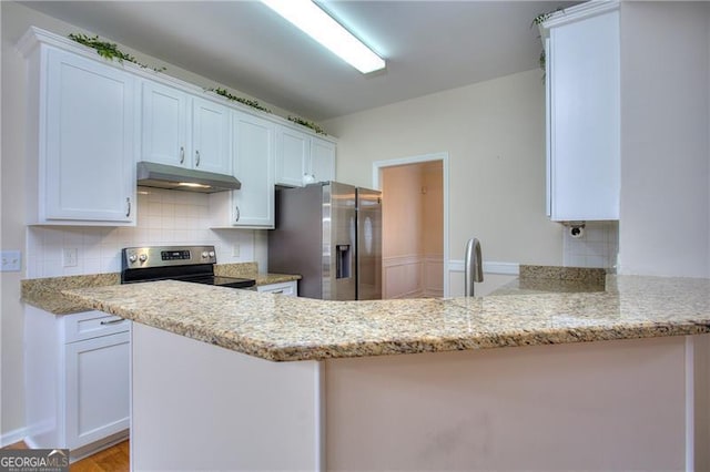 kitchen with white cabinetry, stainless steel appliances, kitchen peninsula, and light stone countertops