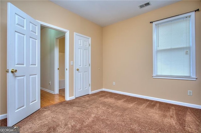 unfurnished bedroom featuring carpet flooring and multiple windows