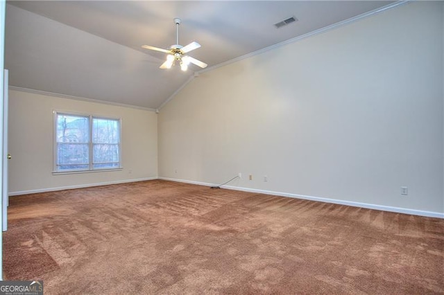 carpeted spare room with vaulted ceiling, ornamental molding, and ceiling fan