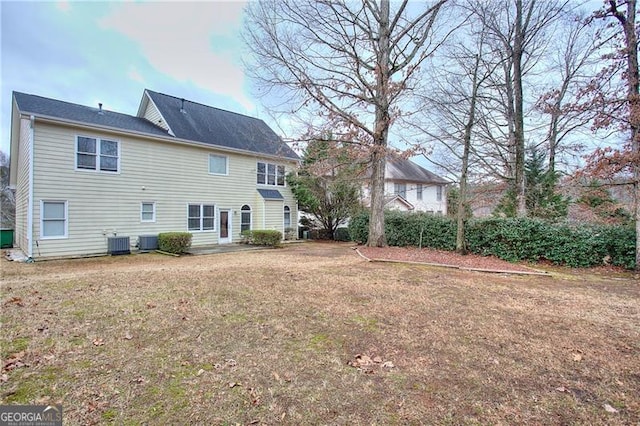 rear view of house with a yard and cooling unit