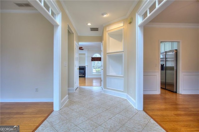 hall with crown molding and light hardwood / wood-style flooring