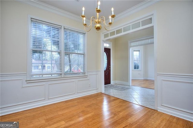 interior space with crown molding, light wood-type flooring, and a chandelier