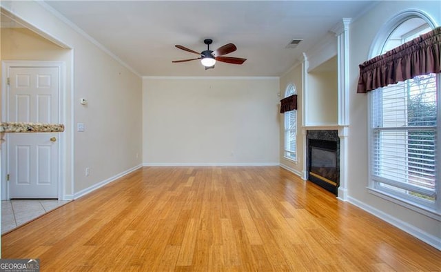 unfurnished living room featuring ornamental molding, ceiling fan, and light hardwood / wood-style flooring