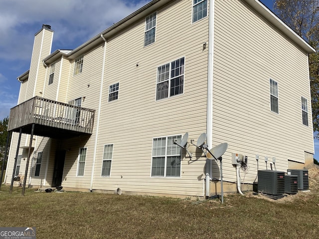 rear view of property featuring cooling unit and a yard