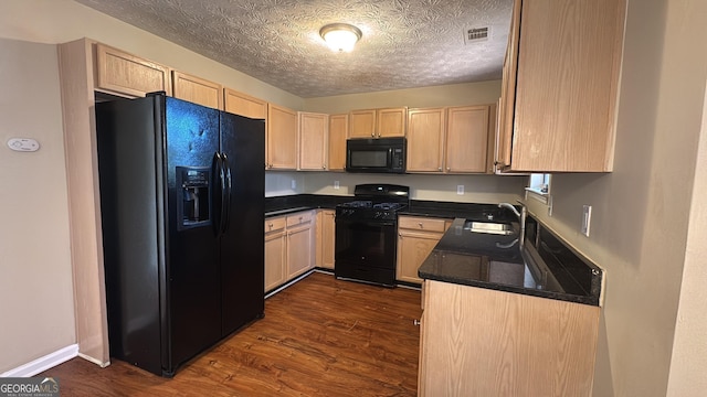 kitchen featuring dark hardwood / wood-style floors, light brown cabinets, a textured ceiling, black appliances, and sink