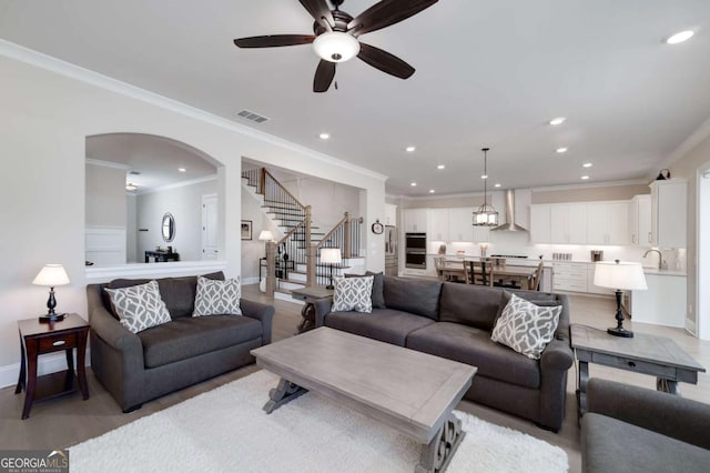 living room featuring ceiling fan and ornamental molding