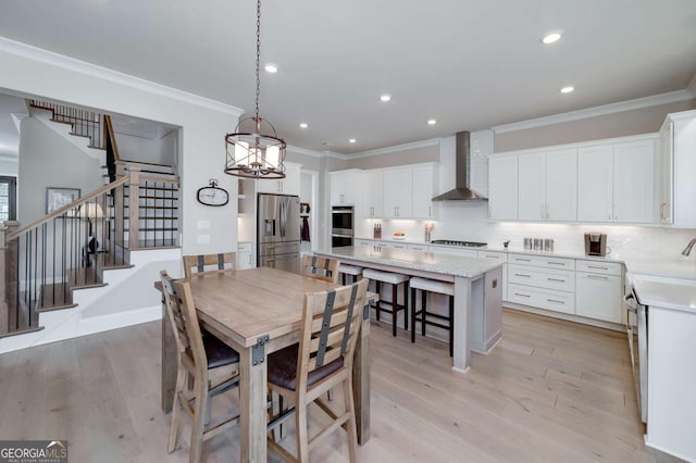 dining room with sink, crown molding, and light wood-type flooring