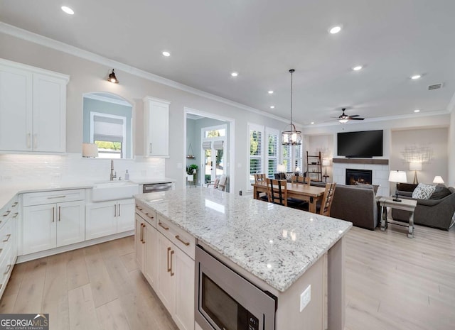 kitchen with white cabinets, appliances with stainless steel finishes, sink, and a kitchen island