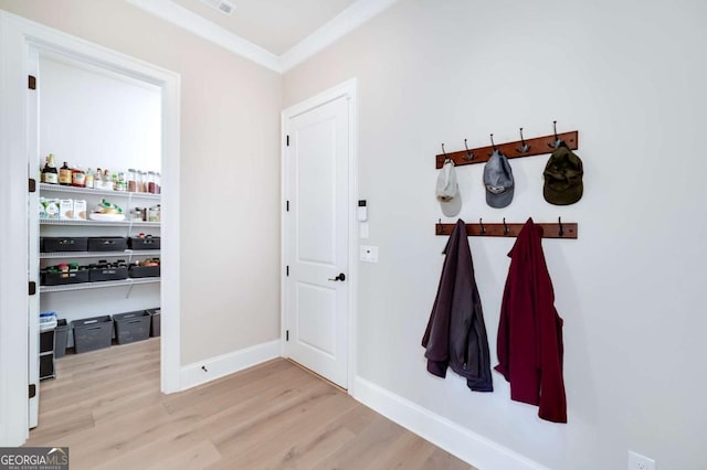 corridor featuring ornamental molding and light hardwood / wood-style floors