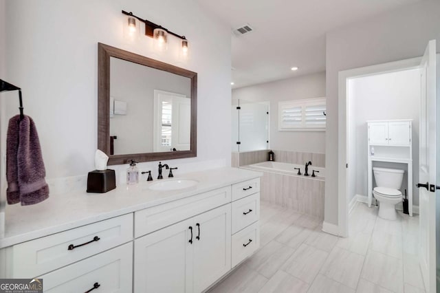 full bathroom with plenty of natural light, tile patterned floors, toilet, and vanity