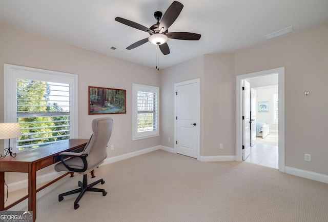 carpeted home office featuring ceiling fan