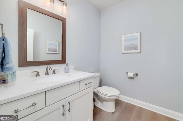 bathroom featuring hardwood / wood-style floors, toilet, and vanity