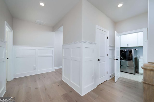 hallway featuring light wood-type flooring and washer and dryer