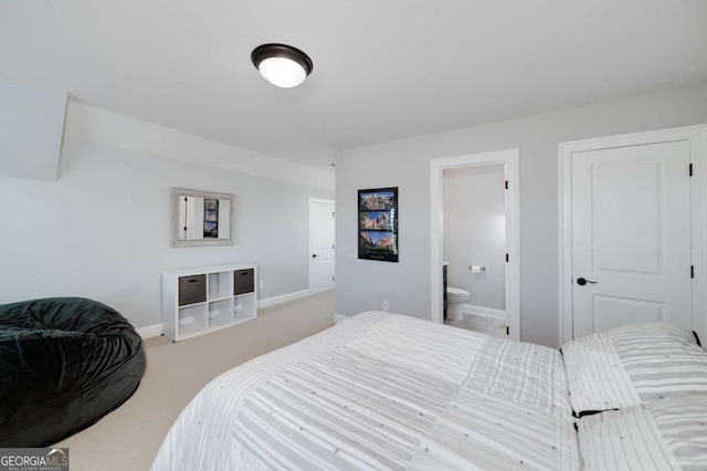 bedroom with ensuite bath and carpet flooring