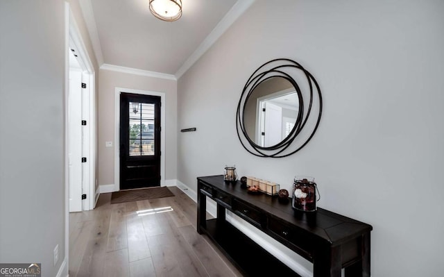 foyer entrance featuring crown molding and light wood-type flooring