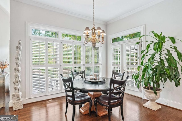 dining space with dark hardwood / wood-style flooring, ornamental molding, and a notable chandelier