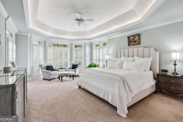 bedroom with ceiling fan, crown molding, light carpet, and a raised ceiling