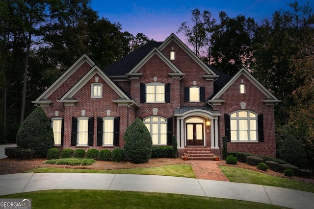 view of front of home with a lawn and french doors