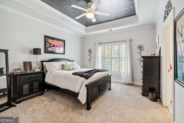 bedroom with a raised ceiling, light colored carpet, ceiling fan, and ornamental molding