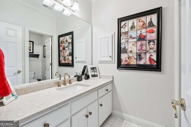 bathroom with toilet, vanity, tile patterned floors, and ornamental molding