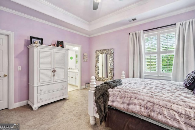 carpeted bedroom with ceiling fan, crown molding, ensuite bathroom, and a raised ceiling