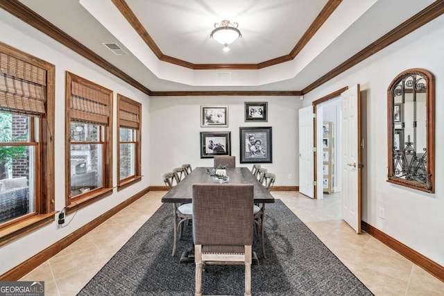 dining space featuring light tile patterned floors, ornamental molding, and a raised ceiling