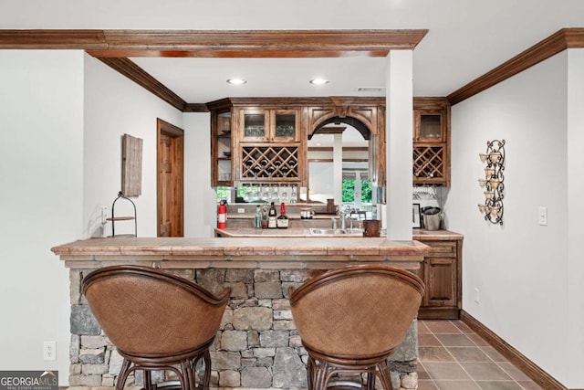 bar featuring ornamental molding and sink