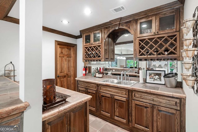 kitchen featuring sink, tile countertops, and ornamental molding