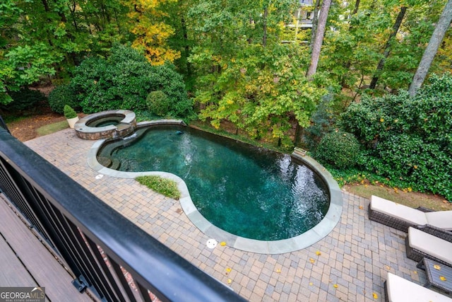 view of pool featuring a patio area and an in ground hot tub