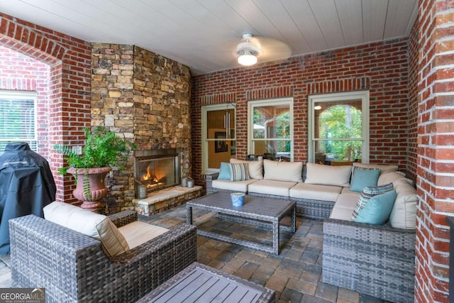 view of patio featuring ceiling fan and an outdoor living space with a fireplace