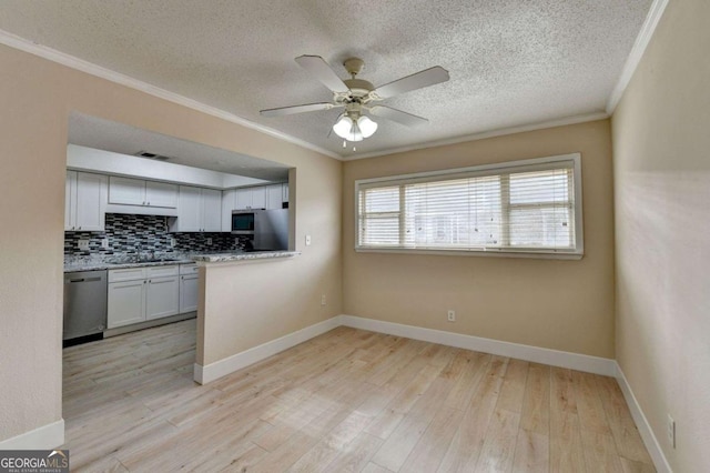 kitchen with light hardwood / wood-style floors, appliances with stainless steel finishes, decorative backsplash, white cabinets, and sink