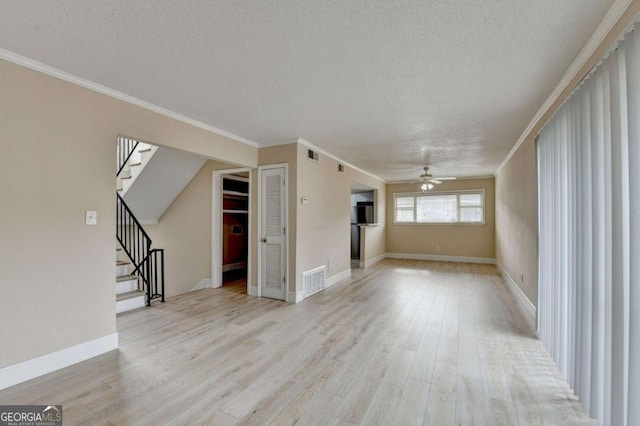 unfurnished living room featuring ceiling fan, a textured ceiling, light hardwood / wood-style flooring, and crown molding