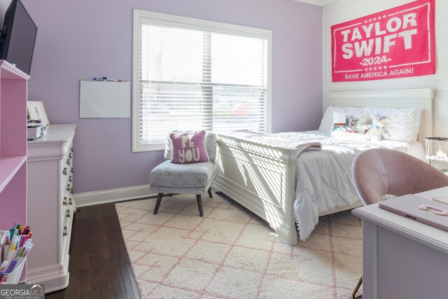 bedroom with dark hardwood / wood-style floors and ornamental molding