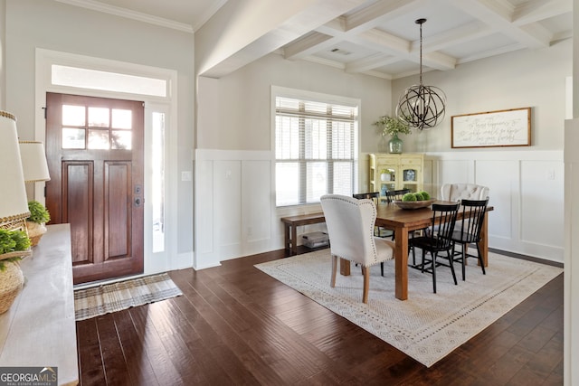 dining area with beam ceiling, crown molding, an inviting chandelier, coffered ceiling, and dark hardwood / wood-style flooring