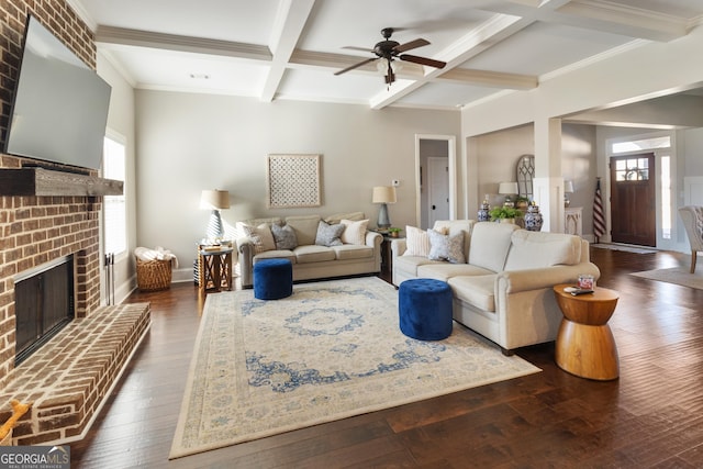 living room featuring coffered ceiling, ceiling fan, a brick fireplace, dark hardwood / wood-style flooring, and beamed ceiling