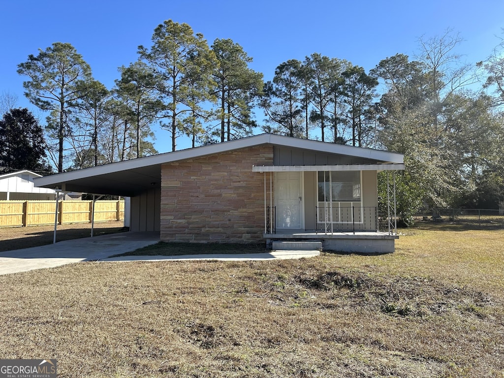 view of front facade with a carport, covered porch, and a front yard