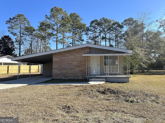 view of front facade with a carport, covered porch, and a front yard