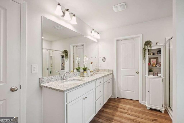 bathroom with an enclosed shower, vanity, and hardwood / wood-style floors