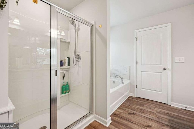 bathroom featuring shower with separate bathtub and hardwood / wood-style floors