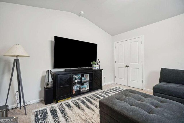 living room featuring lofted ceiling and carpet flooring