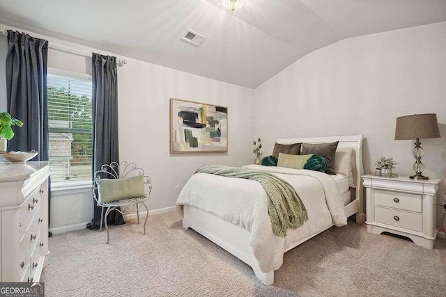 bedroom featuring light colored carpet and vaulted ceiling