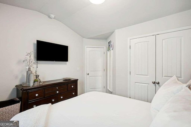 bedroom featuring vaulted ceiling and a closet