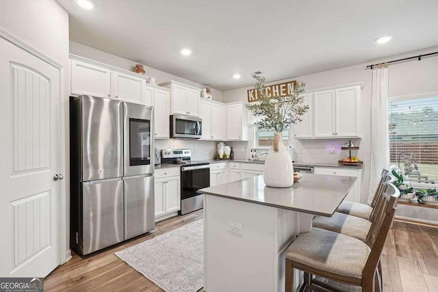 kitchen featuring white cabinets, stainless steel appliances, and a kitchen island