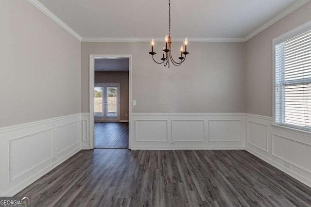 unfurnished dining area featuring dark hardwood / wood-style flooring, ornamental molding, and a notable chandelier