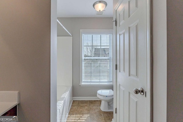 bathroom with toilet, vanity, tile patterned flooring, and a bath