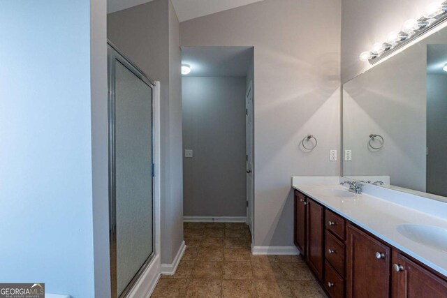 bathroom featuring a shower with door and vanity