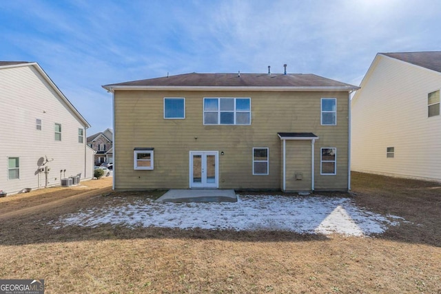 back of property with central air condition unit, french doors, and a lawn