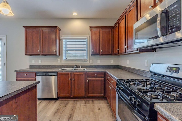 kitchen with sink, stainless steel appliances, and light hardwood / wood-style floors