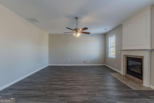 unfurnished living room featuring a premium fireplace, dark hardwood / wood-style flooring, and ceiling fan